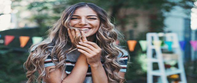 Portrait of a beautiful young woman in the back yard with healthy hair, skin & nails