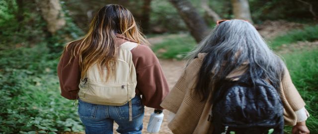 Rear view of mother and daugher hiking in a forest