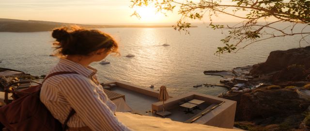 Women travelling looking out over a beautiful sunset across the sea. Can Pycnogenol (pine bark extract) prevent DVT when travelling.