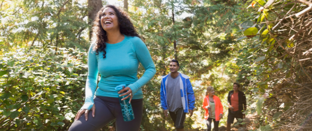 Long covid recovery: group of multi-ethnic friends hiking in the woods in the summer following.