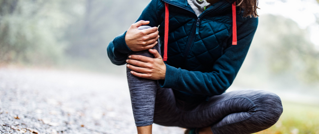 Female runner holding knee in pain, natural pain managment