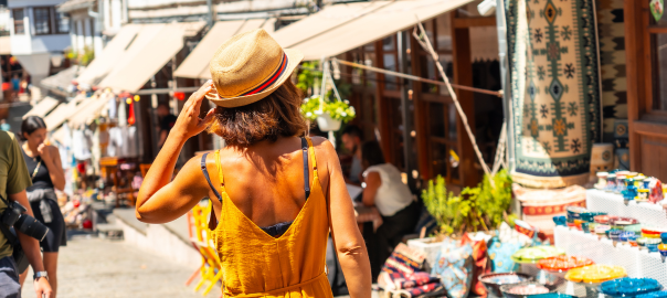 Rear view of a women browing markets whilst travelling abroad. She does not have traveller's diarrhoea as she packed her travel probiotics to look after her gut health.